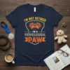 Navy t-shirt with yellow and orange text: "I'm Not Retired I'm A Professional Paw" and paw print graphic