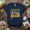 I'm Not Retired I'm A Professional Super Gram t-shirt design with stacked books, building blocks, and a coffee cup