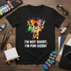 I'm Not Short, I'm Fun Sized! text with a smiling giraffe wearing glasses on a black t-shirt