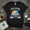 I'm Not Sleeping I'm Just Resting My Eyes funny quote t-shirt with a cartoon character sleeping on a pillow