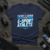 Navy t-shirt with bold blue and white text: "I'M NOT A GAMER I'M AN E-SPORT ATHLETE" design, featuring geometric accents