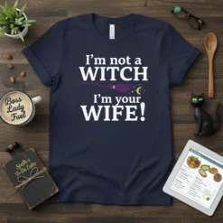 Navy blue t-shirt with white text that reads "I'm not a witch WITCH I'm your WIFE!", featuring a purple witch