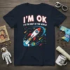 T-shirt with "I'm OK It's The Rest Of The World!" text and a cartoon rocket ship launching from Earth into
