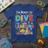 Blue t-shirt with "I'M READY TO DIVE into LEARNING" text, featuring underwater graphics like a submarine, shark, fish, and coral