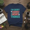 Navy blue t-shirt with "I'm Rory Doing Rory Things" text in colorful, playful font with gear and lightbulb graphics