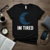 Black t-shirt with a blue crescent moon graphic looking tired and the text "IM TIRED" below it
