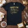 Black t-shirt with gold text "I'M WITH THE Birthday Queen" and crown graphic, celebrating a birthday