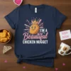 I'm A Beautiful Chicken Nugget graphic t-shirt featuring a smiling chicken nugget wearing a crown. Text is in pink and