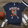 Proud Basketball Mom T-Shirt with graphic of a woman playing basketball and text "I'm A Proud Basketball Mom"