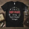 Black t-shirt with white and red text reading "I'm a Tarot Reader doing Tarot Reader things" surrounded by celestial graphics