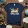 I'M A TEACHER t-shirt with open book, glasses, apple, pencils, and ruler graphic