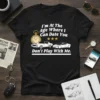 T-shirt with white text "I'm At The Age Where I Can Date You Don't Play With Me" and graphics of