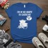 Blue t-shirt with white text "I'm in no shape to exercise" and a graphic of a chair surrounded by snack