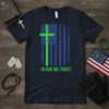 Navy t-shirt with a distressed American flag design featuring a bright green cross and the text "IN GOD WE TRUST"