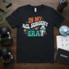 T-shirt with "In My ACL Surgery Era" text and a graphic of a knee joint, flowers, and stars