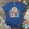 Retro "In My Crochet Era" text with crochet hooks graphic on a blue t-shirt