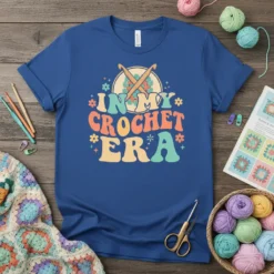 Retro "In My Crochet Era" text with crochet hooks graphic on a blue t-shirt