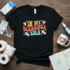 Retro "In My Diarrhea Era" text design on a black t-shirt with toilet paper and toilet graphics