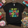 In My Double Digits Era text design with colorful typography and celebratory graphics on a black t-shirt for a 10th