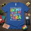 Teacher's "In My End of School Era" t-shirt with colorful retro text and summer icons, declaring "Teacher Off Duty"