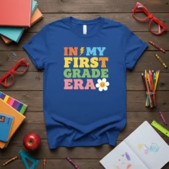 Retro "In My First Grade Era" text design with a lightning bolt and a smiley flower graphic on a blue