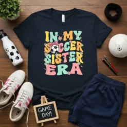 Retro graphic t-shirt with colorful text "IN MY SOCCER SISTER ERA" and a soccer ball with a bow