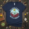 Navy t-shirt with the quote "In a field of roses she is a wildower," featuring a dandelion in a circle