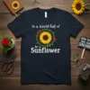 In a World full of be a Sunflower quote on a navy t-shirt with a central sunflower graphic surrounded by