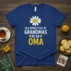 Oma t-shirt with text "In a World Full of Grandmas Be an Oma" and a daisy graphic with heart centers