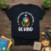 T-shirt design with the quote "In a World Where You Can Be Anything Be Kind", featuring a rainbow flower, dove