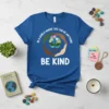 Blue t-shirt with white text "IN A WORLD WHERE YOU CAN BE ANYTHING BE KIND" and a circular graphic of