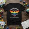 Black t-shirt with "Inclusion Matters We All Learn Differently" text, rainbow phoenix, gears, and open books design