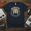 Interstate 290 highway sign graphic on a navy blue t-shirt, featuring a city skyline at sunset