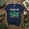 Introverted but willing to discuss plants t-shirt featuring a woman watering plants in a greenhouse