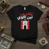 Black t-shirt with Arabic text "تقام عن تين اكو" and a red and white graphic of a historic Iraqi landmark