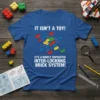 T-shirt with white text "IT ISN'T A TOY! IT'S A HIGHLY SOPHISTED INTER-LOCKNNG BRICK SYSTEM!" and graphic of interlocking building