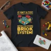 T-shirt with yellow text "IT ISN'T A TOY! IT'S A HIGHLY SOPHISTICATED INTER-LOLCKKING BRiOK SYSTEM!" and a detailed brick construction