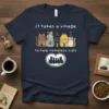 It Takes A Village To Help Homeless Cats quote on a navy t-shirt with cartoon cats and houses design