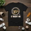 T-shirt design with the text "IT WASN'T ME" and a cartoon Bengal cat jumping inside a stone circle