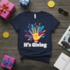 Navy blue t-shirt with "It's Giving" text and a yellow hand graphic with colorful abstract background