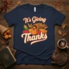 It's Giving Thanks Thanksgiving shirt featuring pumpkins, corn, apples, and wheat graphic