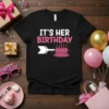 Black t-shirt with "IT'S HER BIRTHDAY" in white and pink text, featuring a pink birthday cake with candles and a
