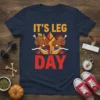 It's Leg Day t-shirt with buff cartoon turkeys wearing headbands and lifting weights, bold text graphic