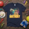 Navy blue t-shirt with "It's my BIRTHDAY" text, featuring a cat wearing a unicorn horn and heart sunglasses, holding a