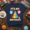 It's My Birthday! text with a cute rainbow poop character, balloons, and confetti on a navy t-shirt