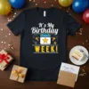 It's My Birthday WEEK! text with calendar graphic, confetti, and gifts on a black t-shirt