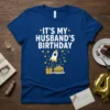 It's My Husband's Birthday text with rocket, cake, and gift graphic on a blue t-shirt