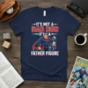 T-shirt with "It's Not a Dad Bod It's a Father Figure" text and a superhero graphic holding a baby