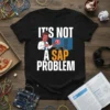 Black t-shirt with white text "IT'S NOT A SAP PROBLEM" and a cartoon man pointing at a computer screen with