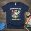Navy t-shirt with "It's A Beautiful Day To Save Teeth" text and a superhero tooth graphic holding dental tools